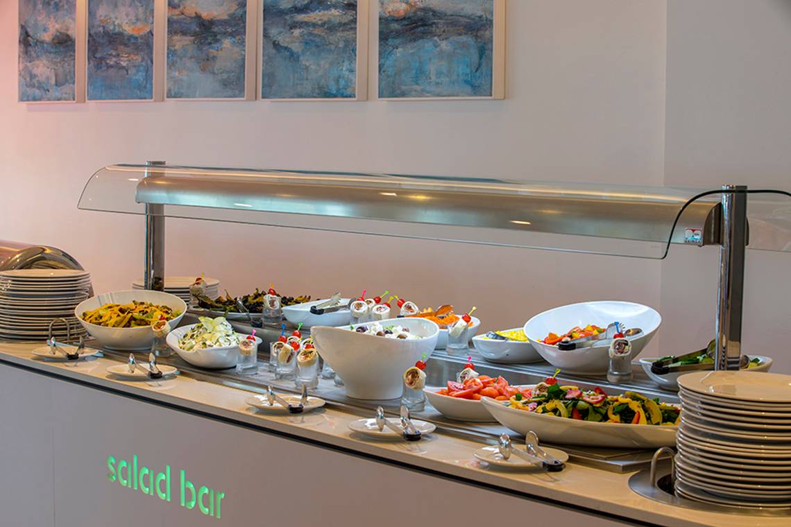Salatbuffet im Faros Hotel Ayia Napa mit verschiedenen Gerichten und Tellern.
