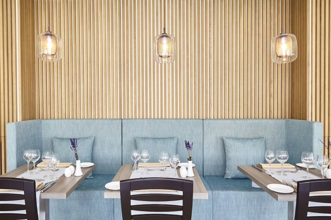 Tisch im Restaurant des Grand Leon & Spa Hotels mit Tischdekoration und Sitzbank.