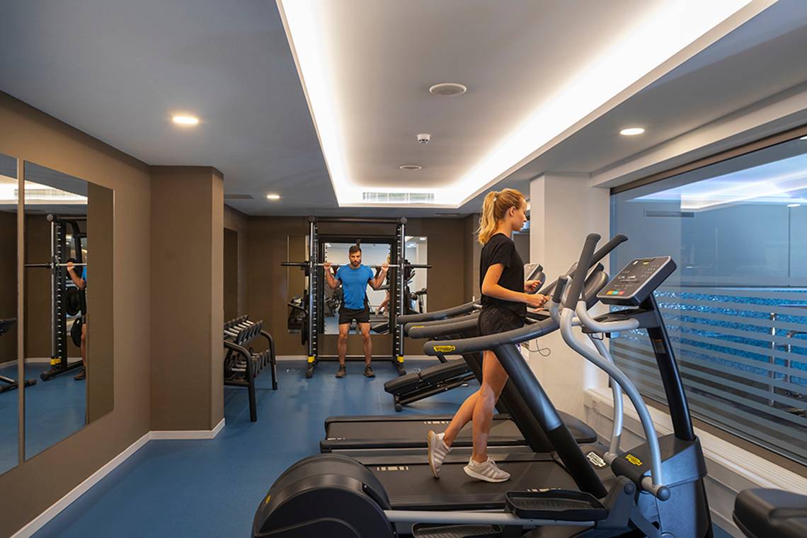 Fitnessstudio im Faros Hotel Ayia Napa mit zwei Personen auf Laufbändern.