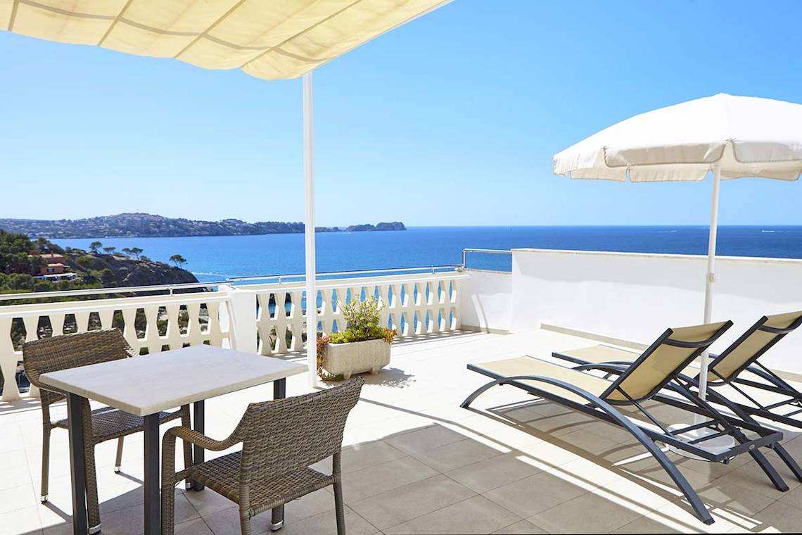 Terrasse im Lido Park Hotel mit Blick auf das Meer und eine grüne Landschaft.