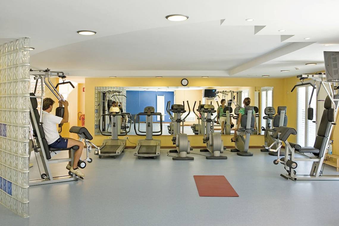 Fitnessstudio im Lido Park Hotel mit verschiedenen Trainingsgeräten und Spiegeln.