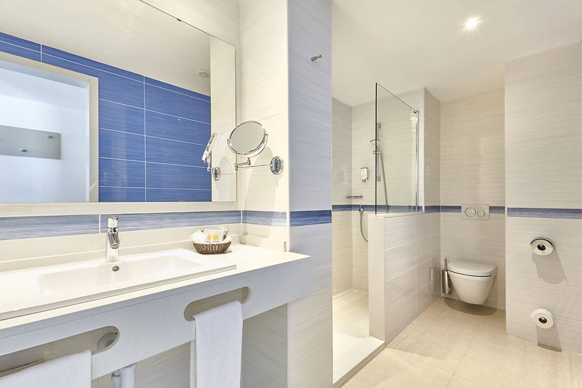 Badezimmer im Lido Park Hotel mit blauen Fliesen und moderner Ausstattung.