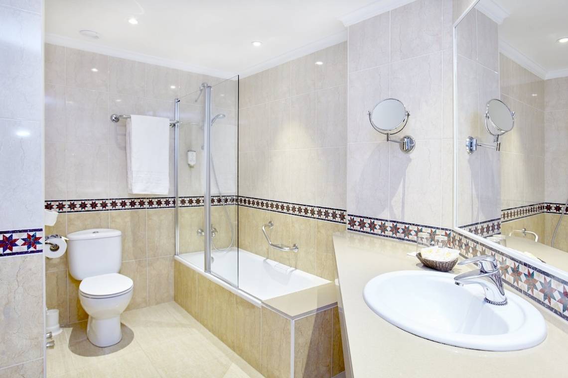 Badezimmer im Lido Park Hotel mit Badewanne, Toilette und Waschbecken.