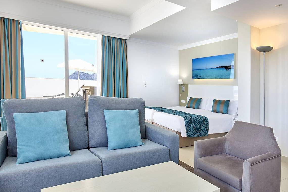Innenansicht eines Hotelzimmers im Lido Park Hotel mit einem Bett, Sofa, Tisch und Aussicht.