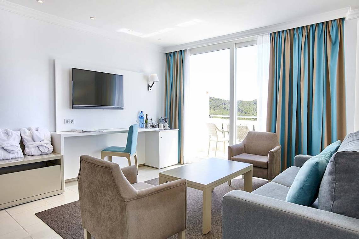 Innenansicht eines Hotelzimmers im Lido Park Hotel mit Fernseher, Schreibtisch und Balkon.