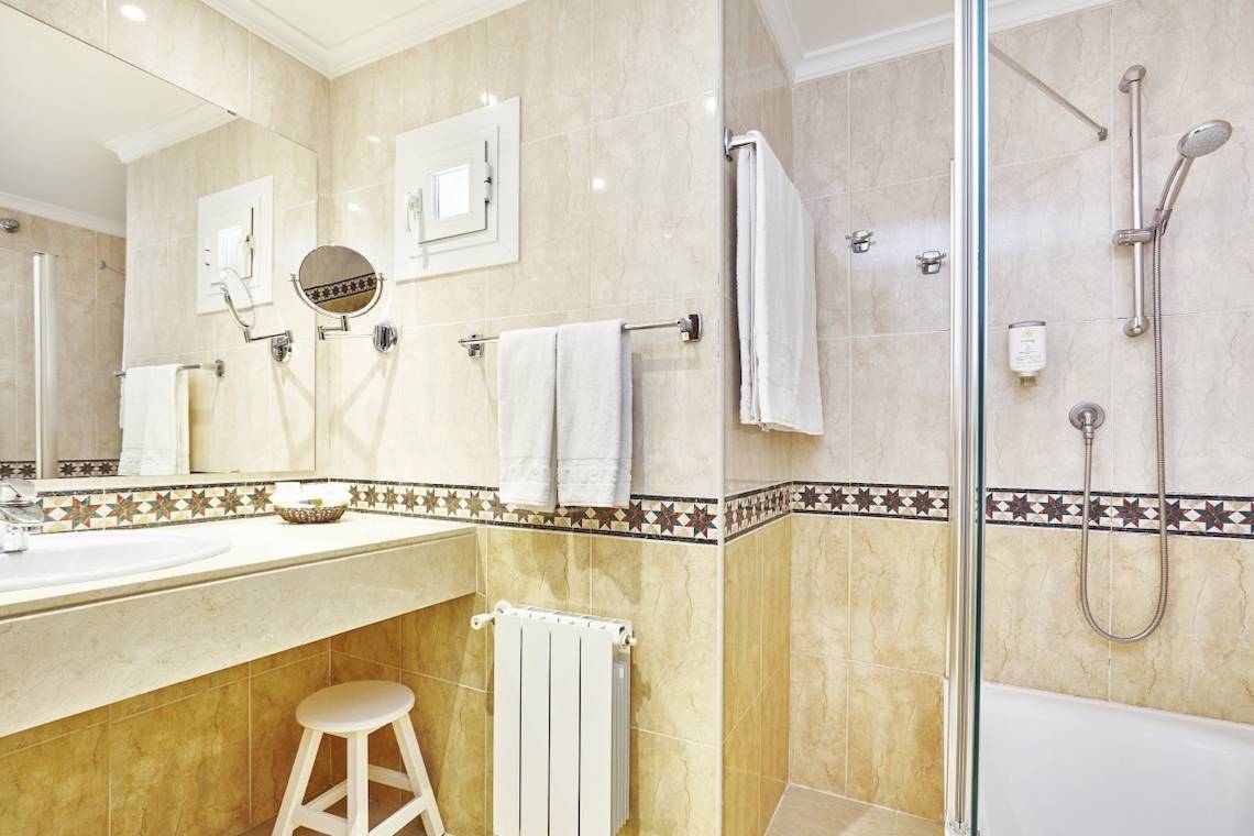 Badezimmer im Lido Park Hotel mit Badewanne, Dusche, Handtüchern und Heizung.