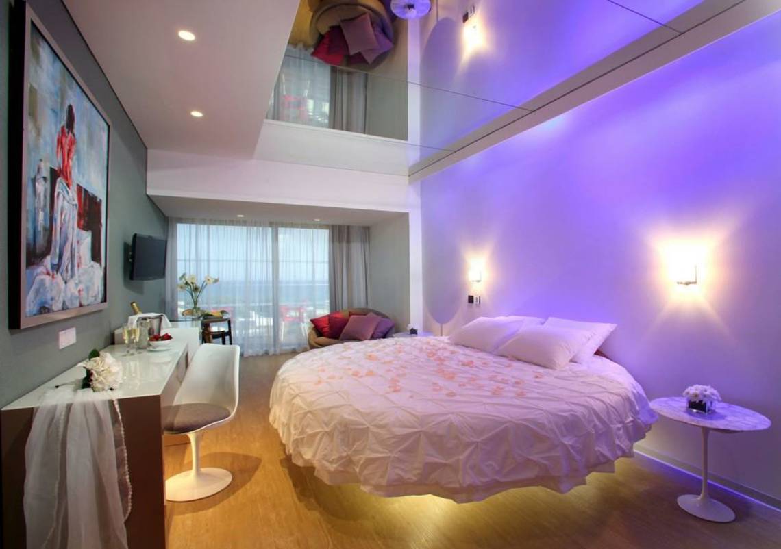 Schlafzimmer im Faros Hotel Ayia Napa mit violetten Lichtern und rundem Bett