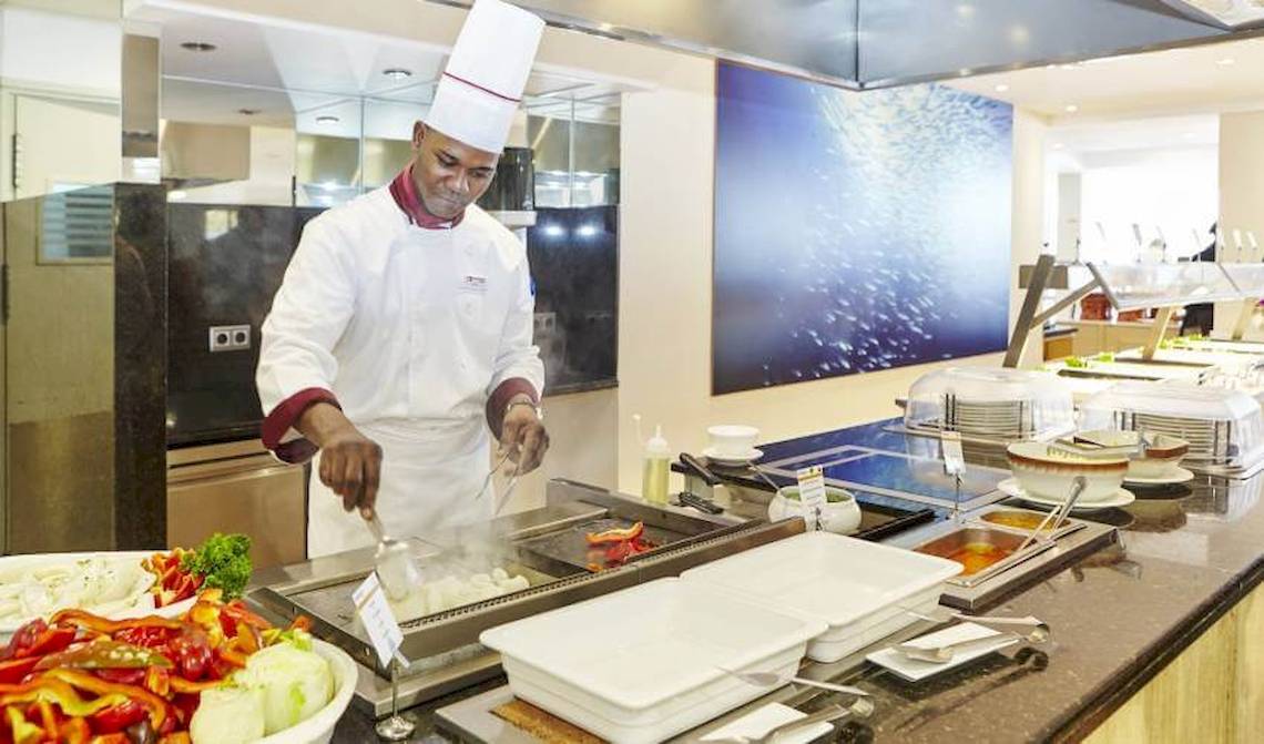 Koch im Restaurant des Marques Hotel beim Kochen mit einem Kochlöffel.