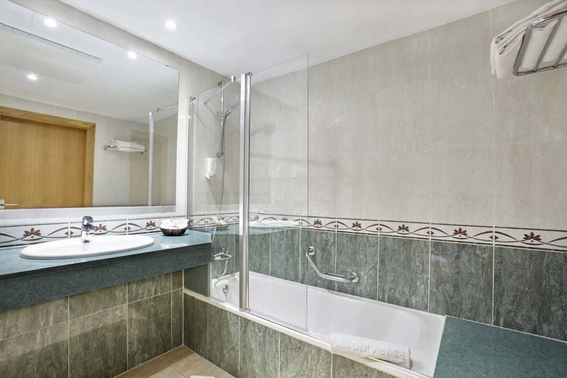 Badezimmer im Marques Hotel mit Badewanne, Dusche und Waschbecken.