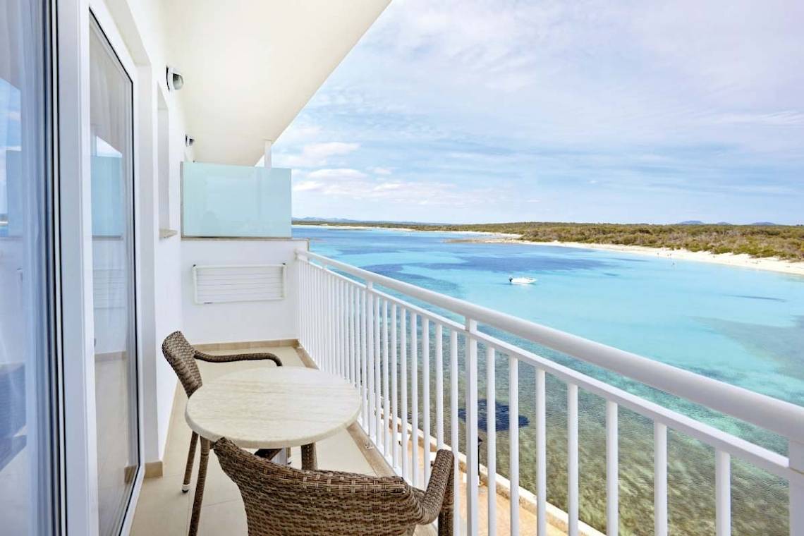 Ein Balkon des Marques Hotels mit Tisch, Stühlen und Blick auf das Meer.