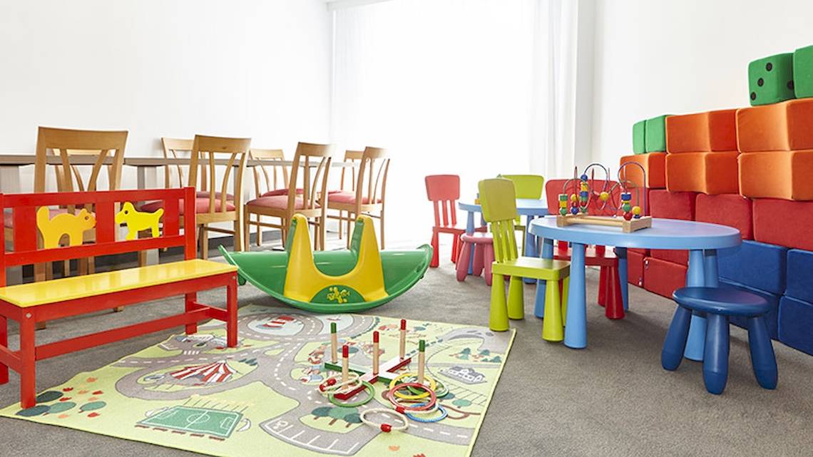 Kinderspielzimmer im Perla Hotel mit bunten Möbeln und Spielzeug.