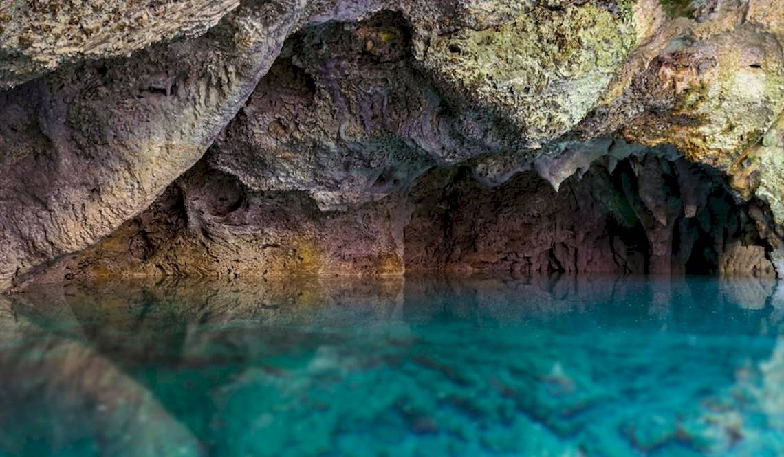 Eindrucksvolles Bild einer Höhle mit türkisfarbenem Wasser und steinigen Wänden im Coral Costa Caribe Beach Resort.