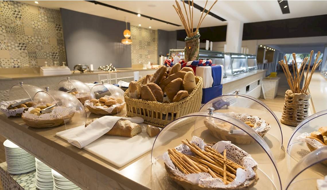 Frühstücksbuffet im Coral Costa Caribe Beach Resort mit Brot, Brötchen und Stöckchen.