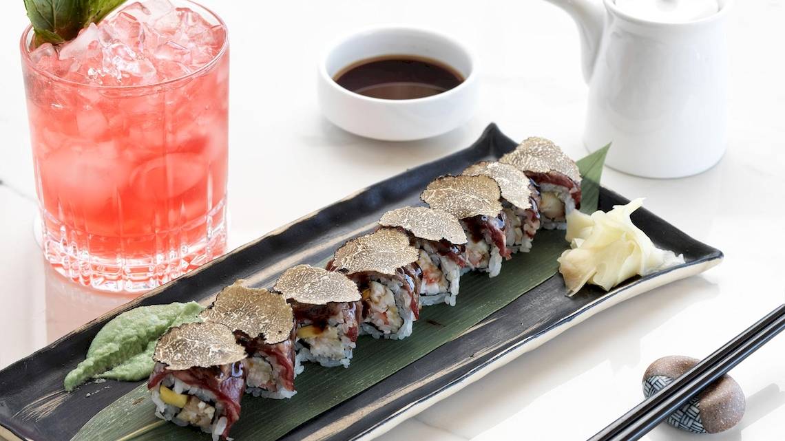 Sushi-Platte mit Gold bedeckt auf einem Teller neben einem Getränk im Katikies Villas Mykonos Hotel.