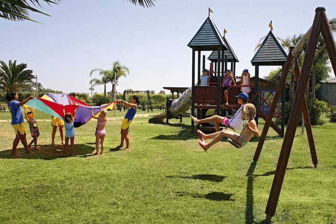 Kinder spielen auf einem Spielplatz im Freien im Sandy Beach Hotel auf Kos.