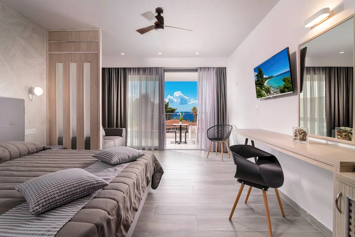 Innenansicht eines Schlafzimmers im Sandy Beach Hotel in Kos mit Blick auf das Meer.