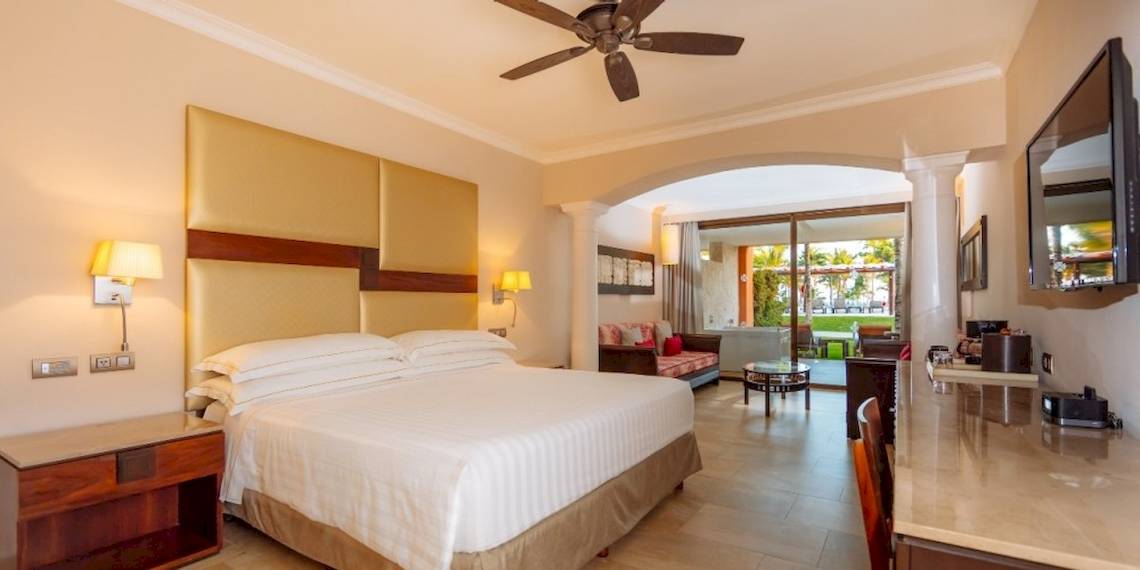 Hotelzimmer im Barcelo Maya Beach mit Bett, Schreibtisch und Klimaanlage.