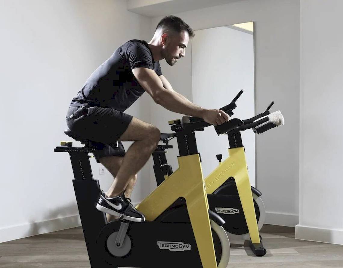 Mann trainiert auf einem Technogym-Fahrrad im Fitnessstudio.