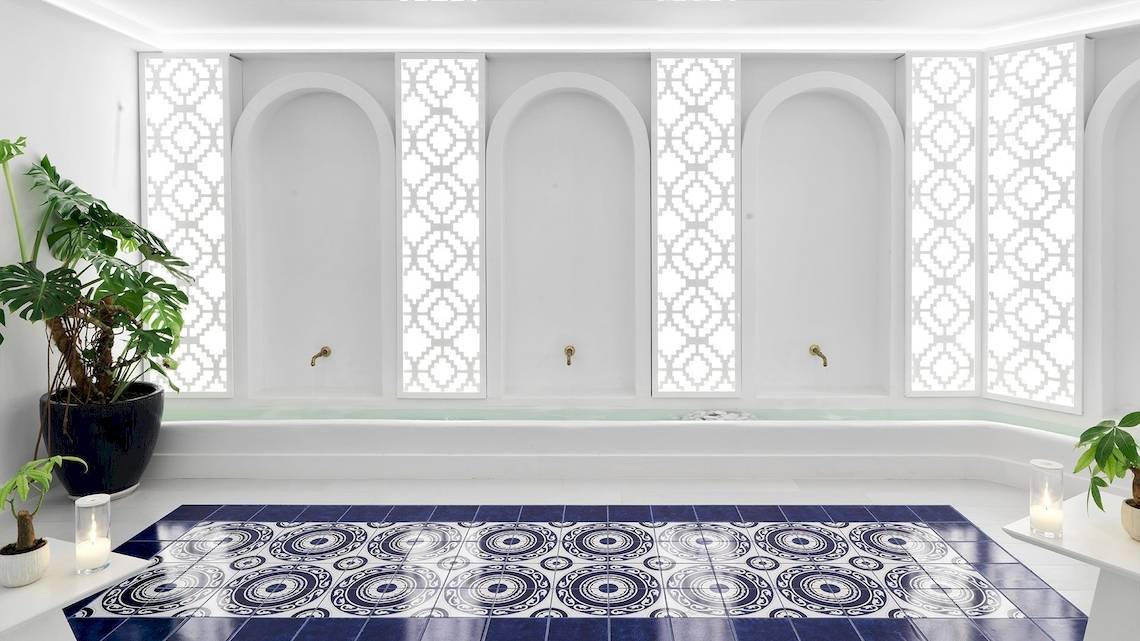 Badezimmer der Katikies Villas Mykonos mit blau-weißen Fliesen und Pflanzen.