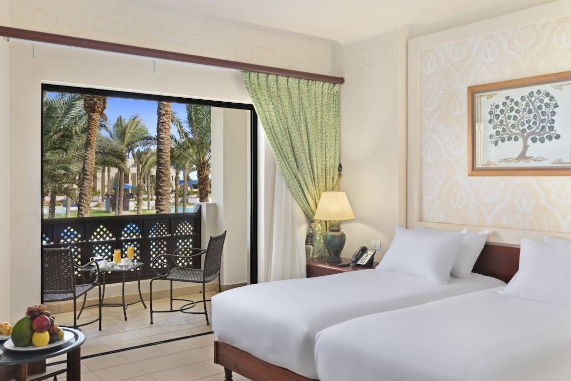 Doppelzimmer im PickAlbatros Oasis Port Ghalib Hotel mit Balkon und Ausblick auf Palmen.