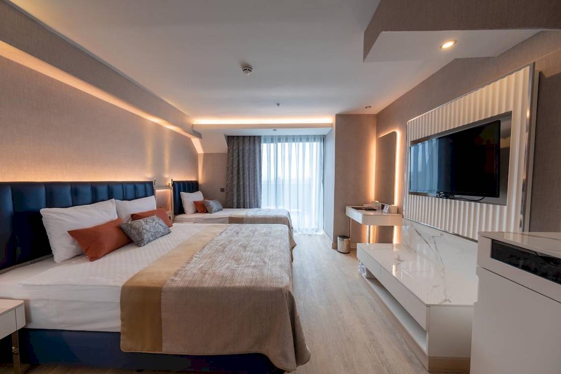 Doppelzimmer im Lago Hotel mit zwei Betten, Fernseher und modernen Möbeln.