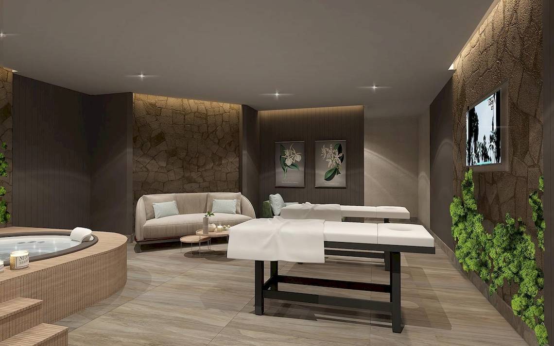 Innenansicht des Wellnessbereichs im Lago Hotel mit Whirlpool, Sofa, Massagetischen und Pflanzenwand.