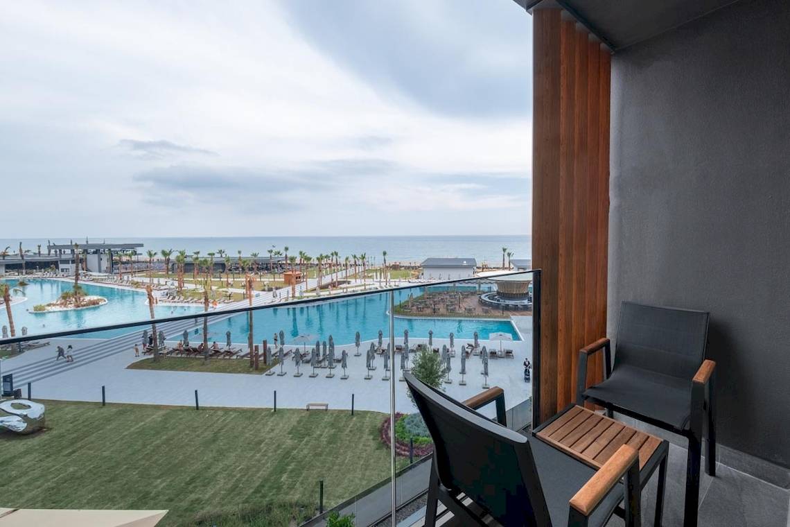Aussicht vom Balkon des Lago Hotels mit Swimmingpool und Meer im Hintergrund.