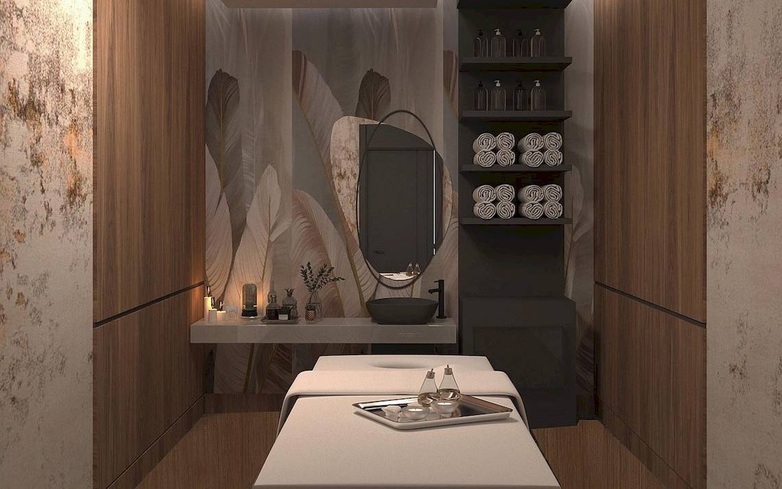 Innenansicht des Behandlungsraums im Lago Hotel mit zwei Behandlungstischen, einem Waschbecken, einem Spiegel und Regalen mit Handtüchern.