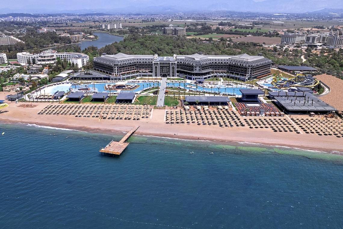 Luftaufnahme des Lago Hotels mit großen Swimmingpools und Sonnenliegen am Strand