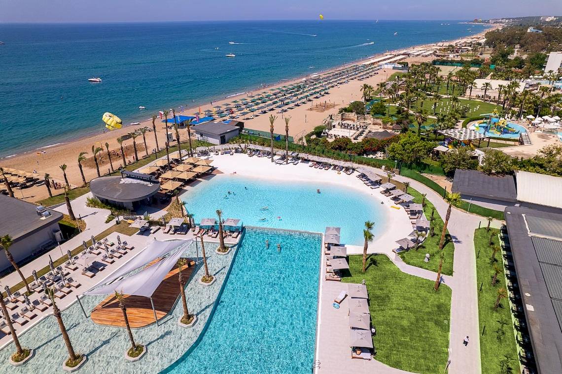 Luftaufnahme des Lago Hotels am Strand mit Swimmingpool und Umgebung