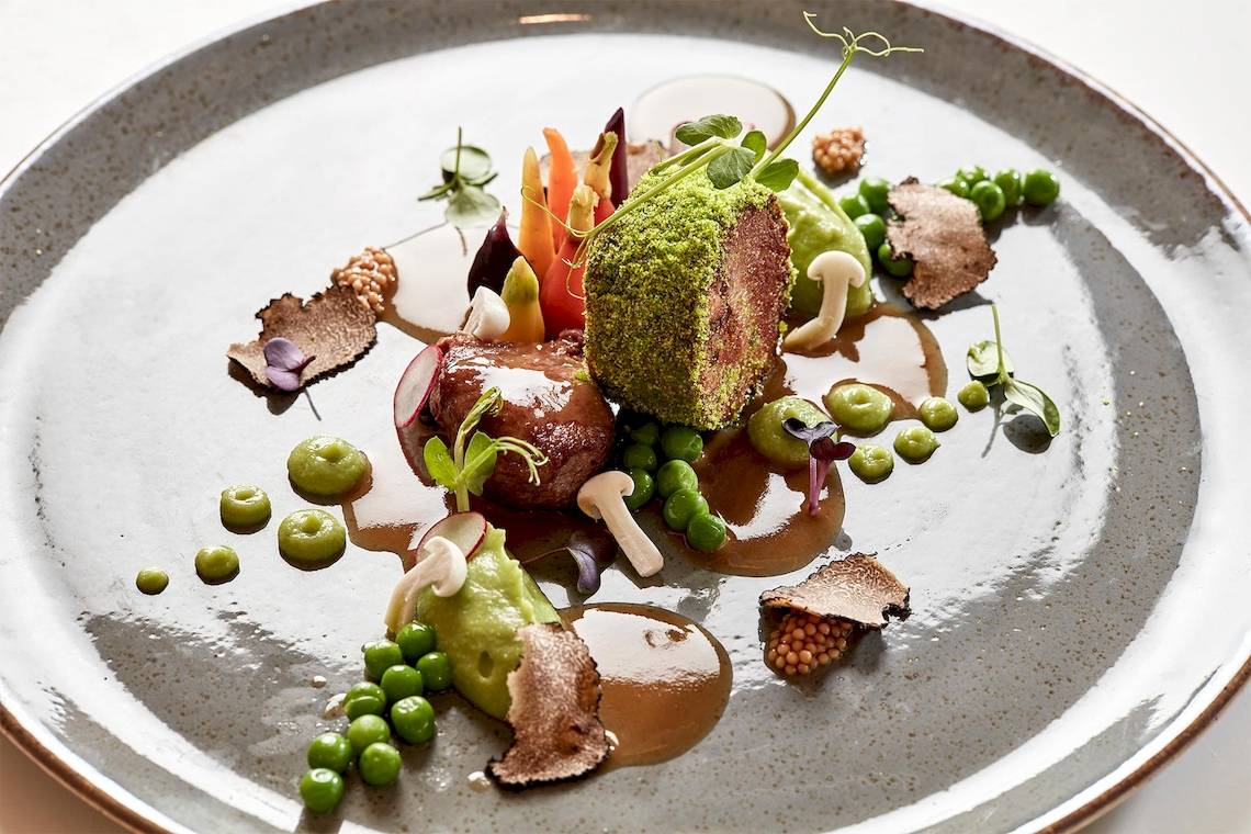 Archipelagos Hotel Gericht mit Fleisch, Gemüse und Sauce auf einem Teller