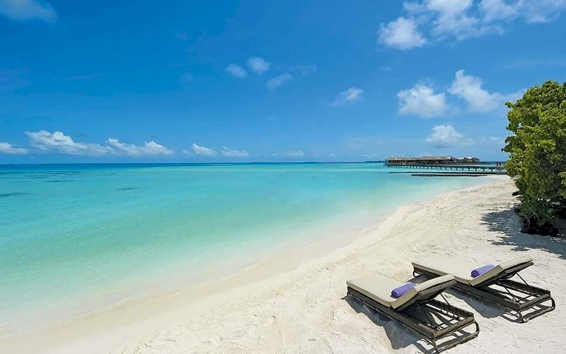 Strand des Constance Ephelia Mahe Seychelles Hotels mit zwei Liegen und blauem Ozean