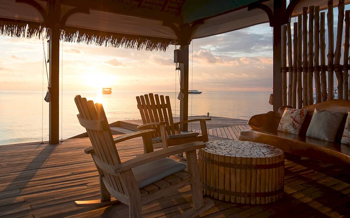 Terrasse des Constance Ephelia Mahe Seychelles mit Blick auf den Sonnenuntergang über dem Ozean.