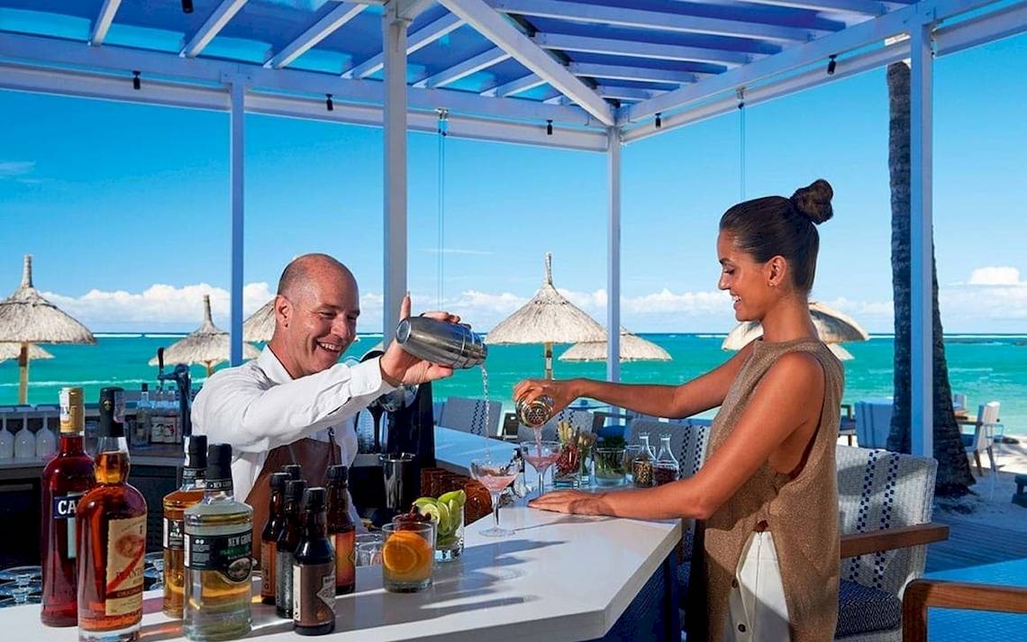 Ein Barmitarbeiter im Constance Ephelia Mahe Seychelles bereitet einen Cocktail zu.