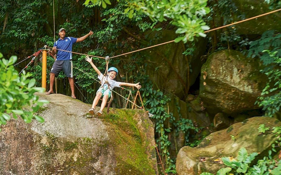 Kind beim Zipline-Abenteuer im Dschungel von Mahe, Seychellen