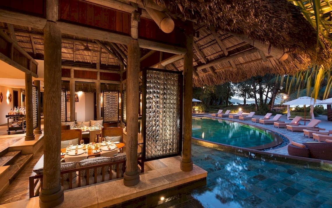 Außenbereich des Constance Ephelia Mahe Seychelles Hotels mit Swimmingpool und Loungestühlen.