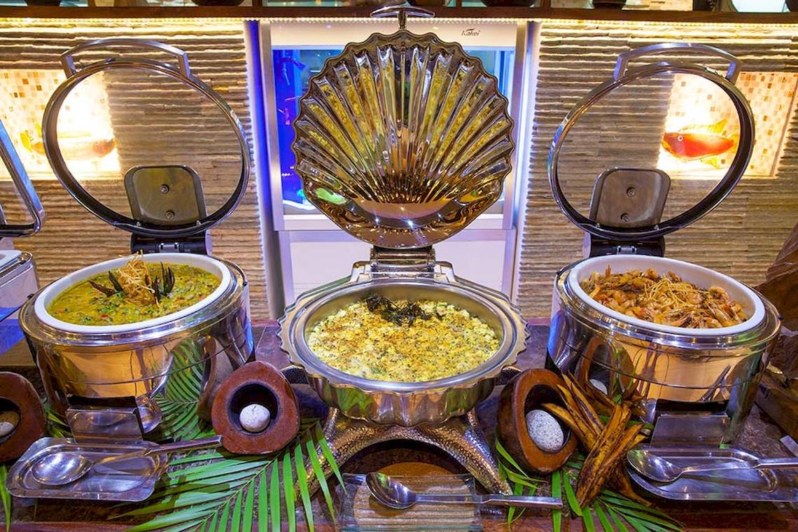 Buffet-Essen im Le Duc de Praslin Hotel & Villas mit verschiedenen Gerichten in silbernen Schalen.