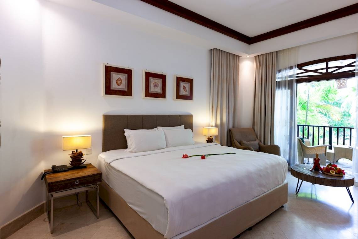 Hotelzimmer im Village du Pecheur mit einem großen Bett, Balkon und Blick auf die Außenterrasse.