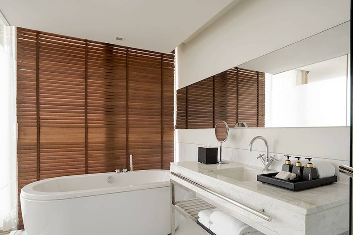 Badezimmer im JC Kevin Sathorn Bangkok Hotel mit Badewanne und Waschbecken.