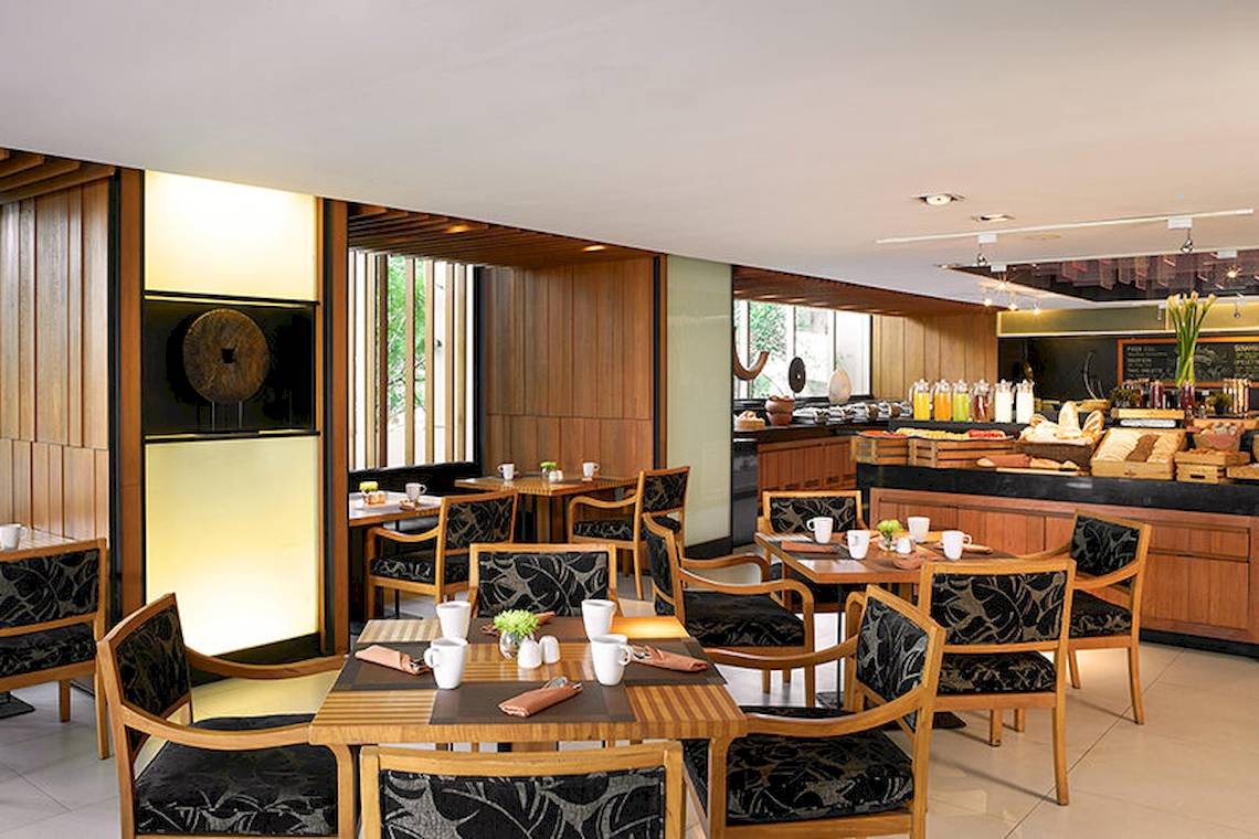 Frühstücksraum im JC Kevin Sathorn Bangkok Hotel mit Holzmöbeln und Buffet.