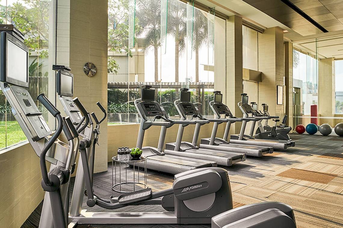 Fitnessstudio im JC Kevin Sathorn Bangkok Hotel mit mehreren Laufbändern und Trainingsgeräten.