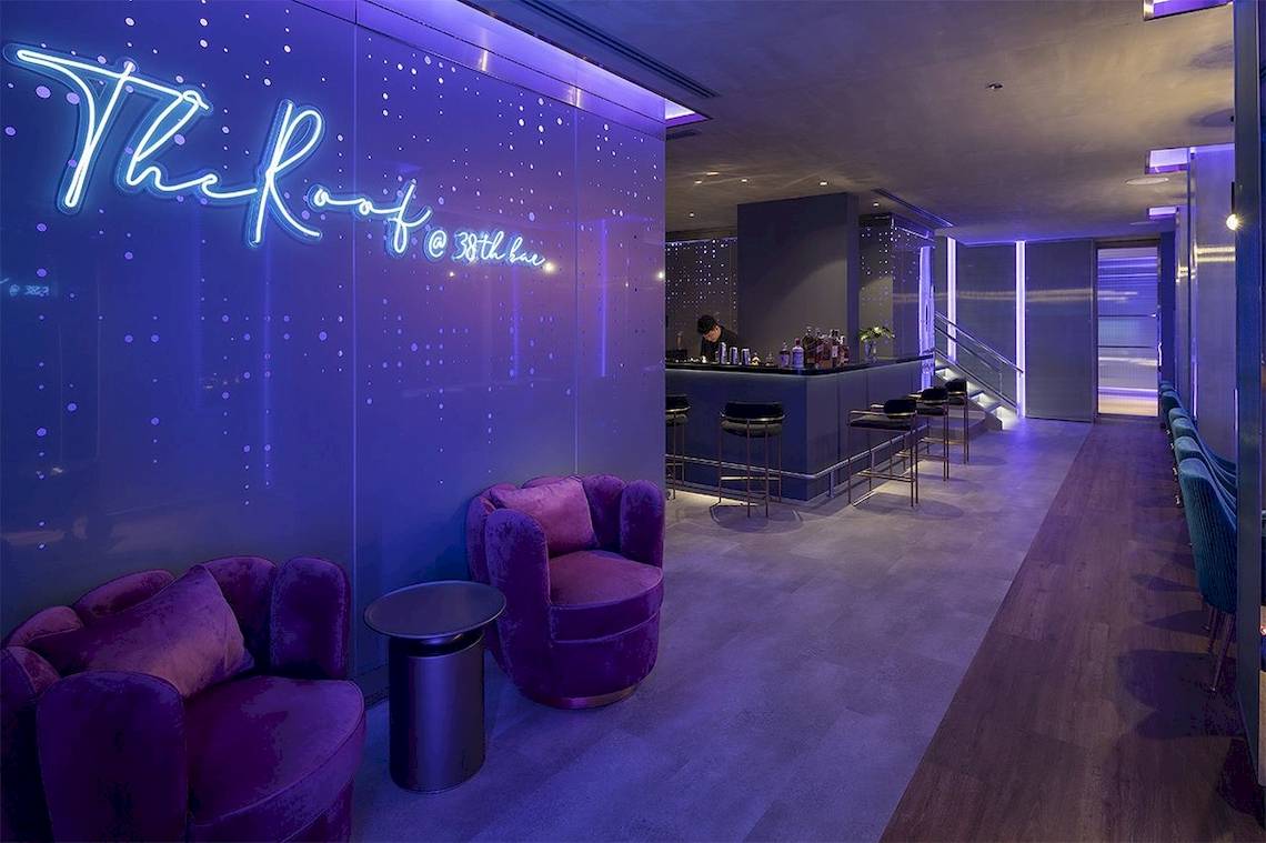 Lobby des Mode Sathorn Hotels mit Bar, violetten Möbeln und Beleuchtung