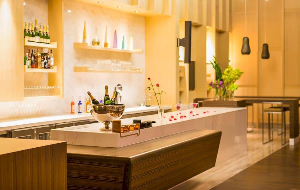 Bar im AVANI+ Riverside Bangkok Hotel mit Flaschen, Cocktails und Dekor