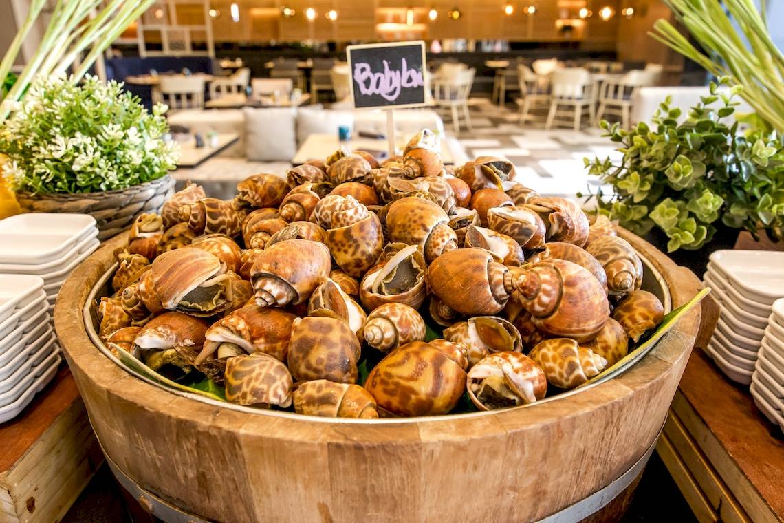 Ein Holzfass voller gebratener Schnecken im Hotelrestaurant