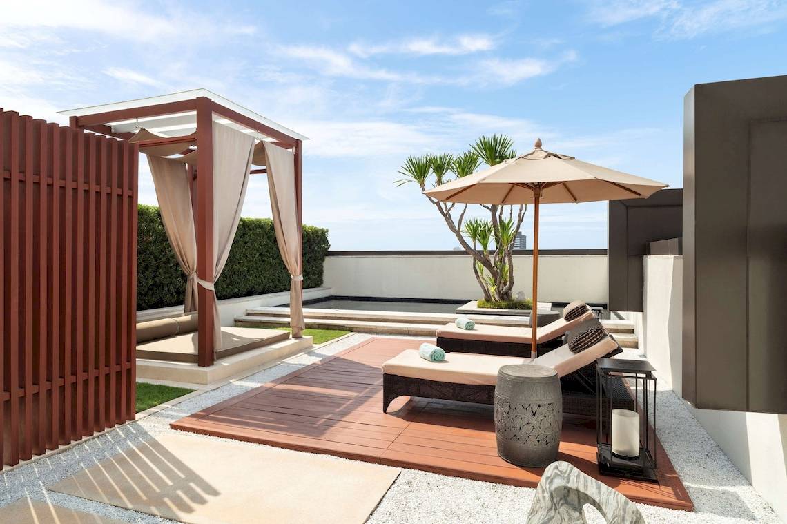 Hotelterrasse mit Liegen und einem Sonnenschirm im Freien