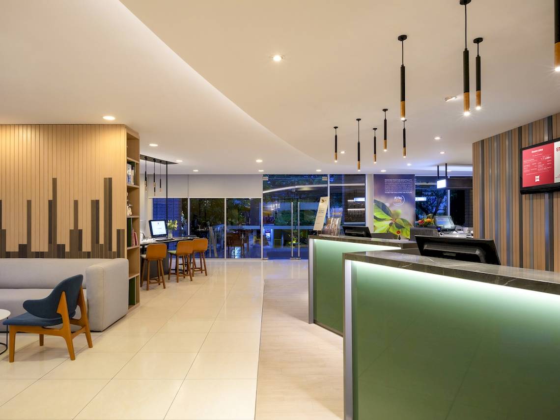 Lobby des Pullman Bangkok Hotel G mit Rezeption, Schreibtischen und Möbeln.