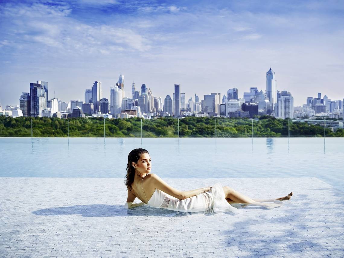 Frau im Pool vor der Stadtlandschaft des SO/ Bangkok