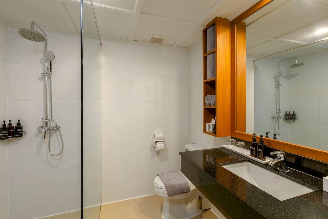 Badezimmer im Sunprime Kamala Beach Hotel mit Dusche, Toilette und Waschbecken.