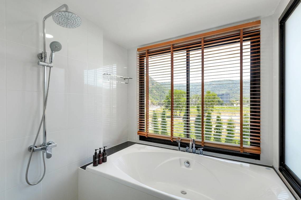 Badezimmer mit Badewanne und Dusche im Sunprime Kamala Beach Hotel