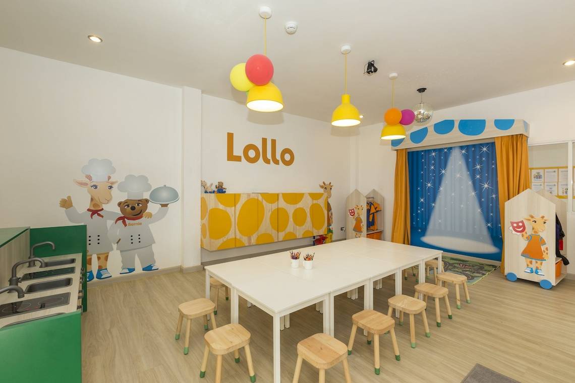 Innenraum des Sunwing Bangtao Beach Hotel Kinderzimmers mit einem langen Tisch und Stühlen.